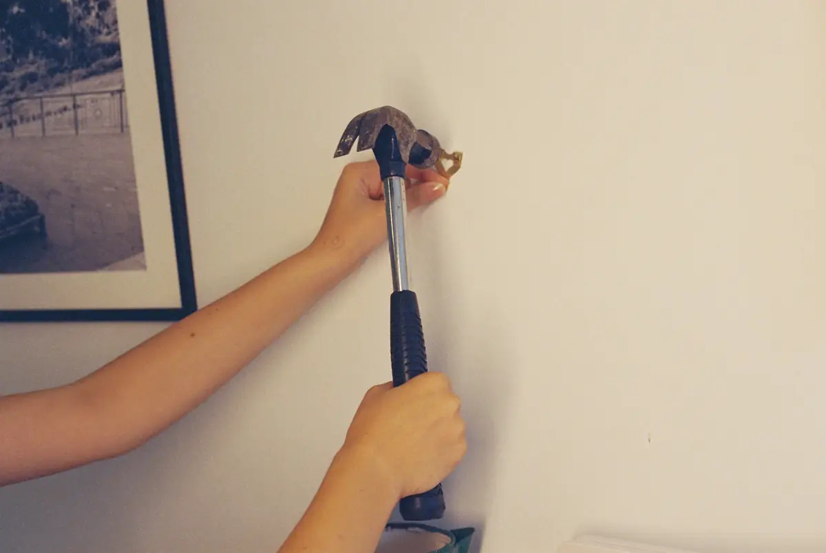 Hammering a hook into a wall